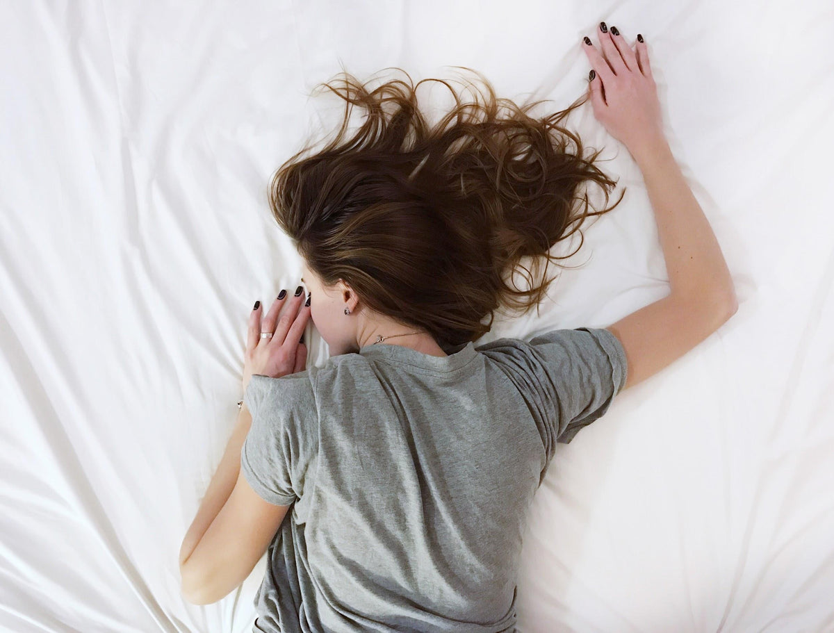 a woman lying face down on a white sheet