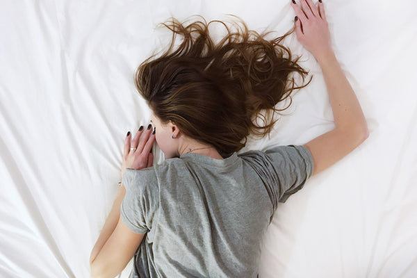 a woman lying face down on a white sheet