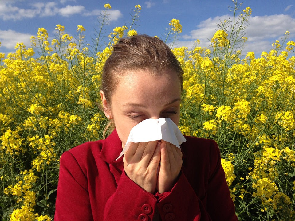 girl has allergies from pollen flower and wipe his nose by tissue paper