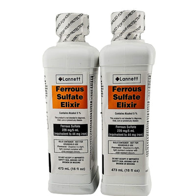 Two bottles of Lannett Ferrous Sulfate Elixir on a gray background